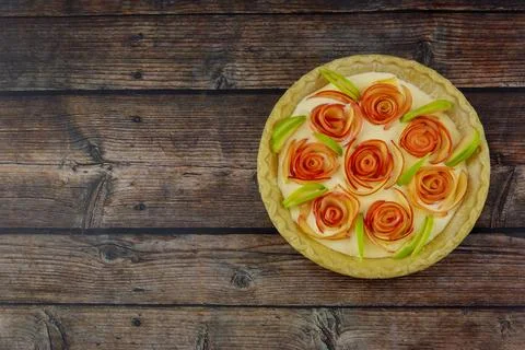 The top view of the apple pie rose shape on rustic wooden background. Stock Photos