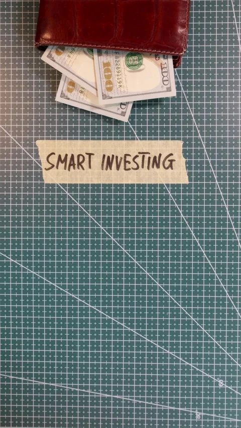 Top view of applying SMART INVESTING tape sticker near money and wallet Stock Footage 338183533