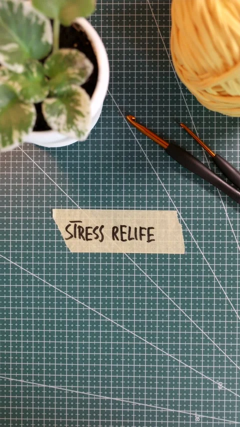Top view of applying STRESS RELIEF handwritten tape near knitting yarn Stock Footage 338183528