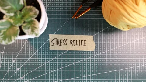 Top view of applying STRESS RELIEF handwritten tape near knitting yarn Stock Footage 338183847