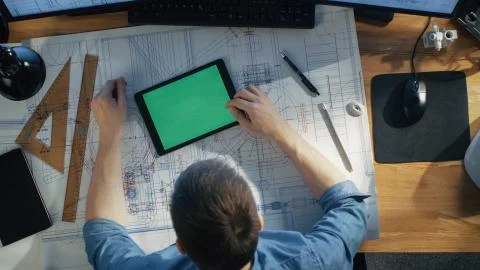 Top View of Architectural Engineer Working with Blueprints, Uses Tablet Stock Photos