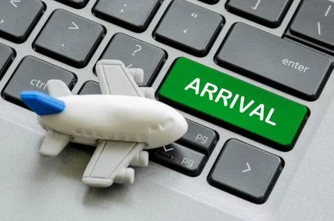 Top view of Arrival text on laptop keyboard with airplane toy background. T.. Stock Photos