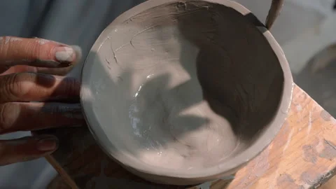 Top view of artisan hands shaping a gray clay bowl by hand Stock Footage 318566814
