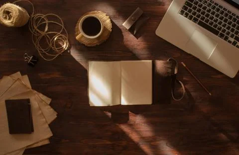 Top view artist desktop with opened handmade vintage sketchbook and coffee Stock Photos