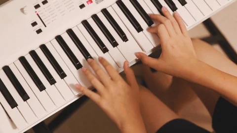 Top view of Asian boy practicing piano at home on white electric piano Stock-Footage 107936443