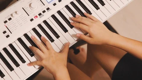 Top view of Asian boy practicing piano at home on white electric piano Stock Footage 107936615