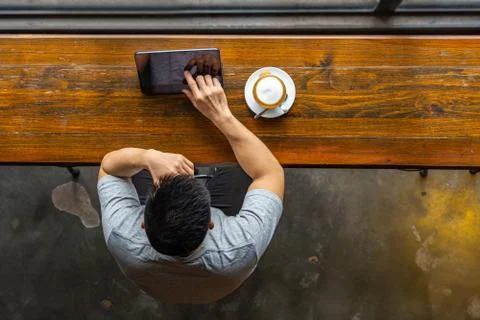 Top view of Asian freelancer using tablet at rustic coffeeshop Stock Photos