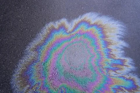 Top view of the asphalt surface with a spreading colorful spot of gasoline Foto stock