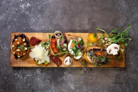 Top view assorted bruschetta with different flavors on a wooden board Stock Photos
