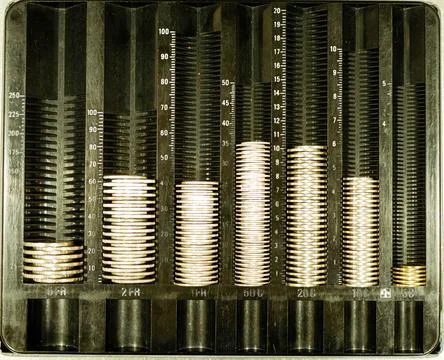 Top view of assorted coin stacks arranged in a money sorting device Stock Photos