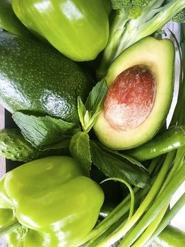 Top view of assorted fresh green vegetables placed on stone table in kitchen Foto stock
