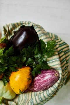 Top view assorted fresh vegetables in reusable cotton bags on table in the ki Stock Photos