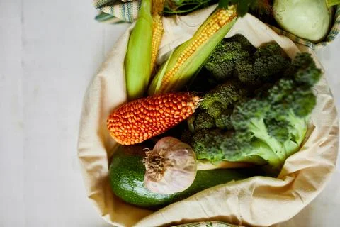 Top view assorted fresh vegetables in reusable cotton bags on table in the ki Stock Photos