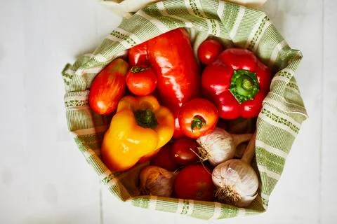 Top view assorted fresh vegetables in reusable cotton bags on table in the ki Stock Photos