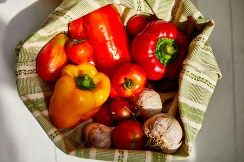 Top view assorted fresh vegetables in reusable cotton bags on table in the ki Stock Photos