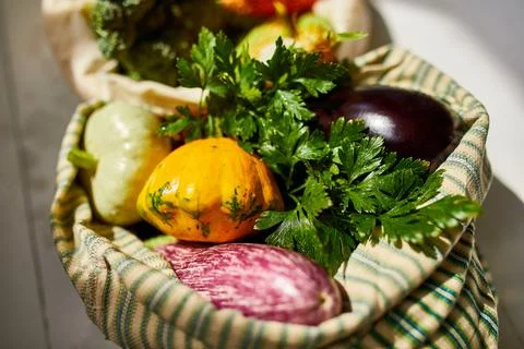 Top view assorted fresh vegetables in reusable cotton bags on table in the ki Stock Photos