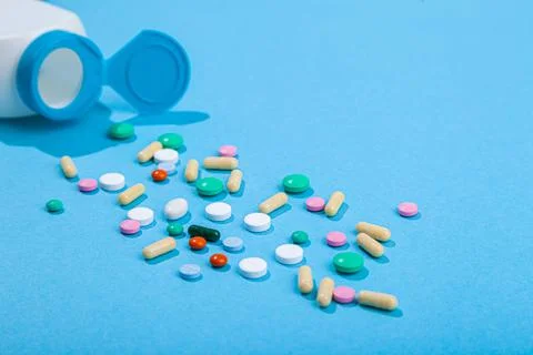 Top view of assorted scattered from pill bottle colorful tablets and capsules Stock Photos