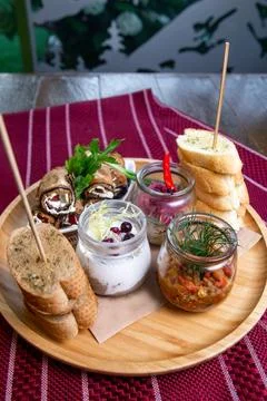 Top view of assorted snacks in jars on a wooden stand on the table Stock Photos