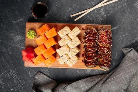Top view on assorted sushi rolls on a wooden board Stock Photos