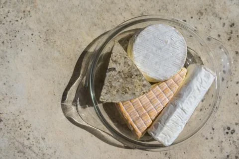 Top view of assorted various types of cheese in glass plate on stone table Stock Photos