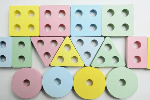 Top view of assorted wooden shape sorter toys in pastel colors, arranged in.. Stockfoto's