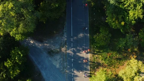 Top view of an athletes running a marathon on the road in the park on a sunny Stock Footage 113863809