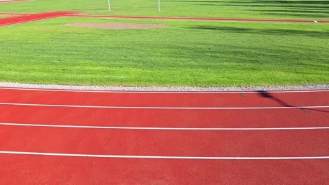 Top view of athletic running track lanes with graphic shadows in slow motion mot Vídeo Stock 333340421