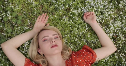 Top view of an attractive young blonde woman lying on forget-me-not flowers Stock Footage 154678416