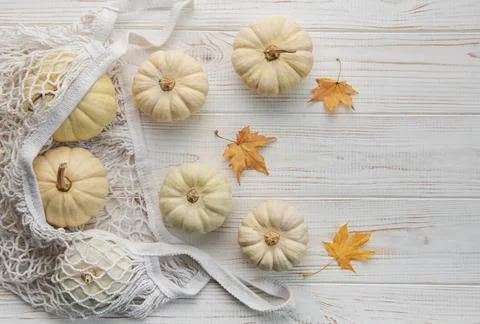 Top view autumn composition with pumpkins in mesh shopping bag Stock Photos