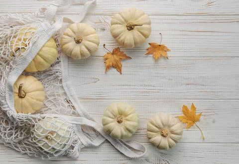 Top view autumn composition with pumpkins in mesh shopping bag Stock Photos