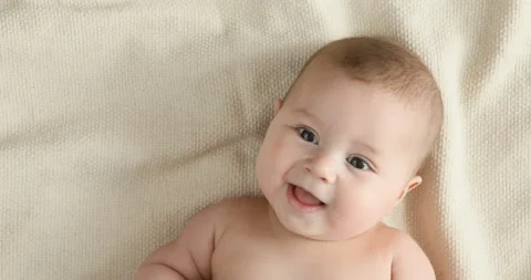 Top view of the baby looking in the camera and smiling, close up 4k shot. Stock Footage 126495471