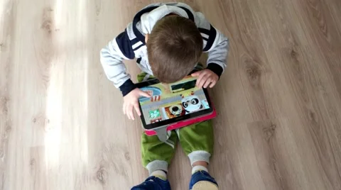 Top view of a baby playing with a big tablet PC games on Android Stock Footage 59964015