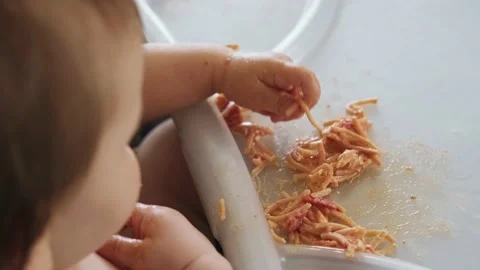 Top view of a baby's table dirty and full of pasta with sous from which the baby Stock Footage 170677047