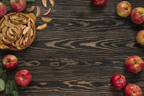 Top view on background with dry apple wedges and fresh apple. Stock Photos