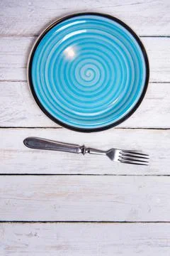 Top view background with empty blue ceramic plate, antique silver cutlery on Stock Photos