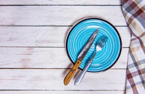 Top view background with empty blue ceramic plate, antique silver cutlery on Stock Photos