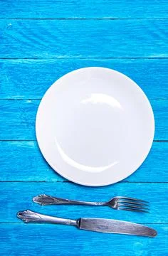 Top view background with empty white ceramic plate, antique silver cutlery on Stock Photos