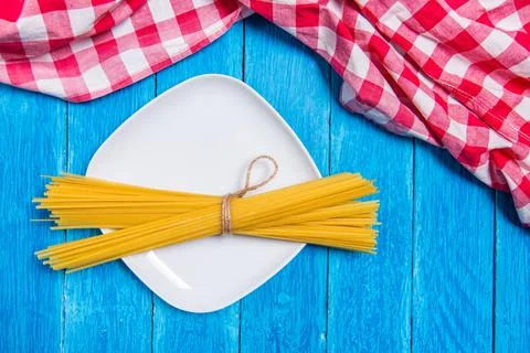 Top view background with squared white ceramic plate with spaghetti package on Stock Photos