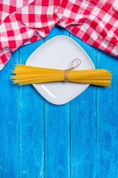 Top view background with squared white ceramic plate with spaghetti package on Stock Photos