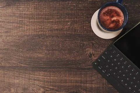 Top view background of tablet and hot drink on wooden desk. Фото