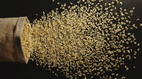 TOP VIEW: Bag falls and pasta letters are poured out of it - Slow Motion Видео 98384944