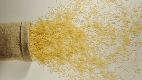 TOP VIEW: Bag falls and filini are poured out of it on white - Slow Motion Vídeos de archivo 98666322