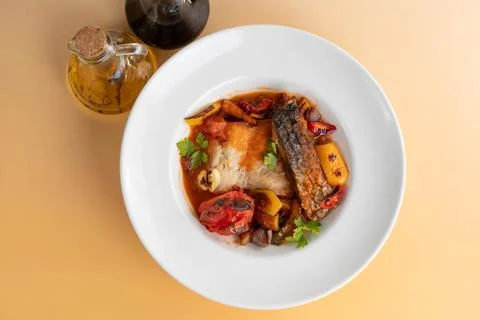 Top view of baked carp fish fillet in tomato sauce with roasted vegetables Stock Photos