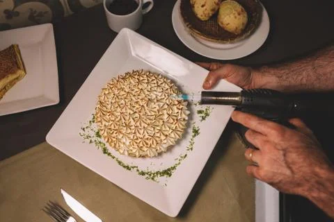 Top view of a baker using a flame on a meringue cake Stock Photos