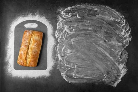 Top view of baking dark background withwith fresh whole loaf of bread and flour Stock Photos