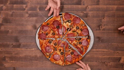 Top view of baking a pizza with hands taking slices 動画素材 73253958