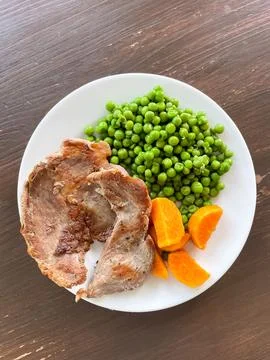 Top view of balanced meal with lean fried pork sweet potato and green peas .. Stock Photos