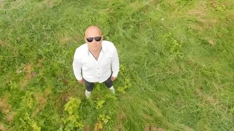 Top view of a bald man standing in the grass. Full shot. Stock Footage 115132606