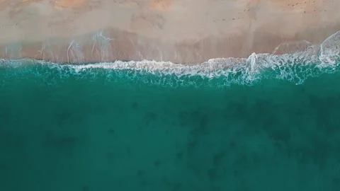 Top view beach and ocean waves transparent green sea waters. Drone view of Stock Footage 243356520