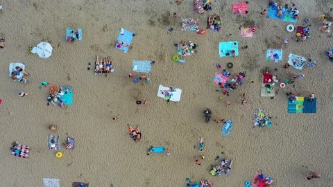 Top view of the beach, featuring colorful umbrellas and people relaxing on a Vídeos de archivo 114623480